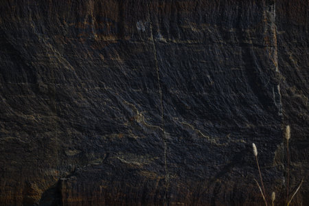 A natural stone texture background with a monolithic rock formation, cracks, and fragments. Ideal for design templates or banners, emphasizing raw, brutal power and natural aesthetics.の写真素材
