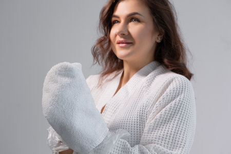 Beauty salon paraffin dip, young womans hands wrapped in wax for nail and skin health.の写真素材