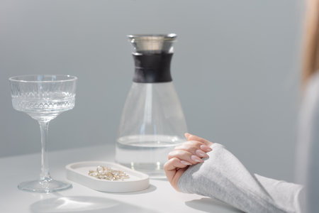 Glamorous beige almond nails, elegant gel manicure close-up with soft lightingの写真素材