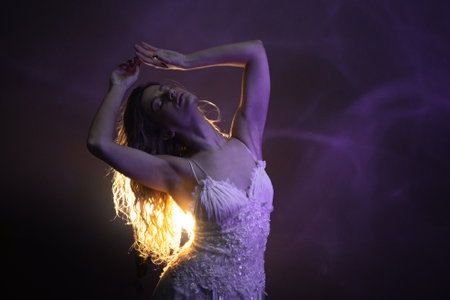 Romantic scene of ballerina in white, glowing backlight creating magical silhouette effect