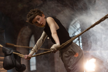 A woman in a boxing gym, portrait by the ropes, close-up. cinematic style, Respite before training,...
