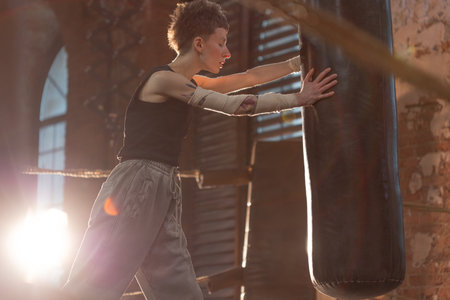 Short-haired fighter in boxing ring, cinematic rest moment between intense rounds.の写真素材