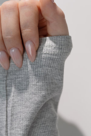 Elegant feminine hand with light manicure in beauty salon, quiet luxury style with tools in...