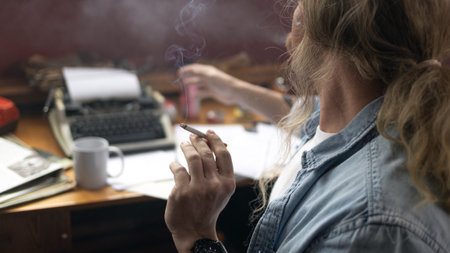 Stressed businessman smoking in dark office, cinematic framing emphasizing bad habits and isolation