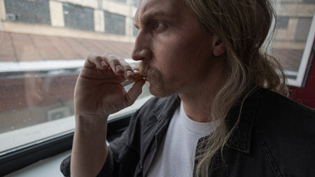 A weary office worker exhales smoke, cinematic shot reflecting stress and nicotine reliance