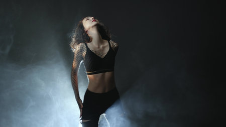Atmospheric dance performance - female dancer in heels executing fluid movements against moody...