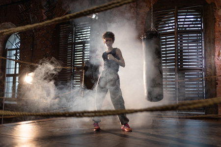 Boxing with a punching bag, sports achievements concept, female wrestler in a boxing ring, cinematic...