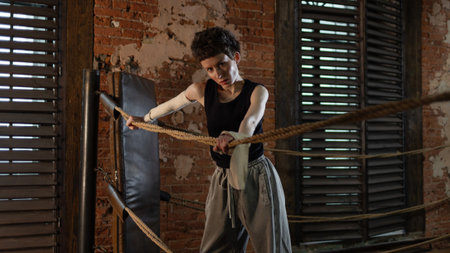 A woman in a boxing gym, portrait by the ropes, cinematic style, dark tones. Training and overcoming...
