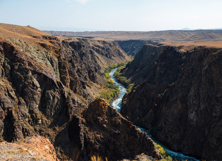 A mountain river flows through the bottom of the canyon, Majestic Kazakh canyon landscape with...
