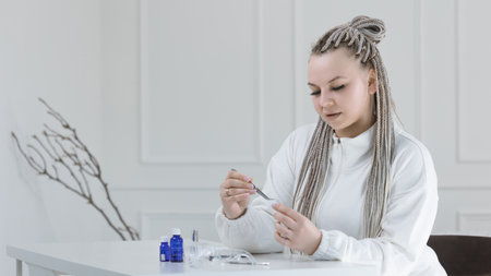 A manicure master at a table in an elegant and bright studio, beauty salonの写真素材