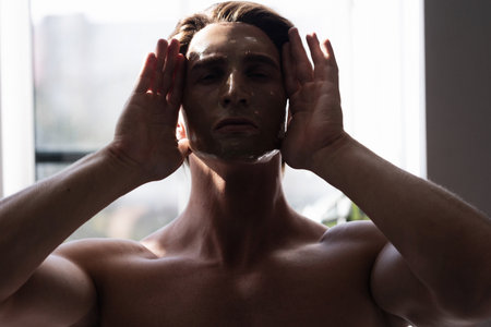 Young muscular man and his facial treatmentsの写真素材