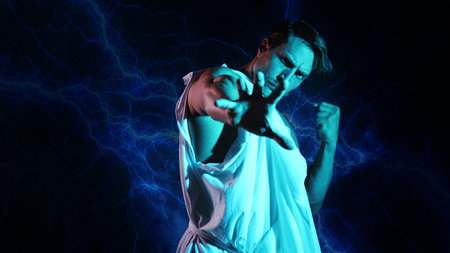 Antique-style Zeus: powerful young god in classical robe against dramatic stormy backdropの写真素材