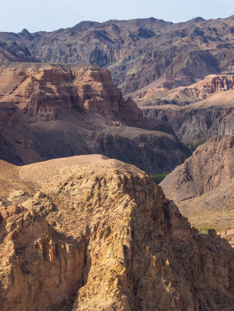 Kazakhstans rugged canyon landscape with undulating red stone walls and desert hues.