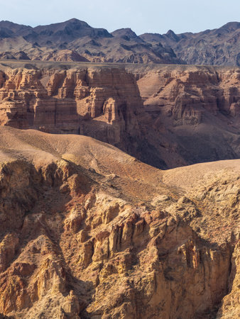 Geological wonder: crimson canyon in Kazakh mountains with surreal eroded formations.