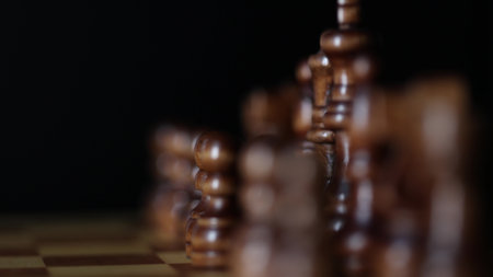 Moving footage of chess pieces on a spinning game board, illustrating the strategic confrontation between opposing black and white armies in mental combat. Slow focus,very low depth of field, perspective blur, macro videoの写真素材