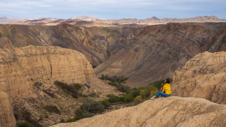 Walking in the canyon, a small figure of a woman walking along the edge of the canyon, huge natural expansesの写真素材