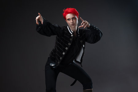 Bold female with short red hair in pirate-inspired suit on dark grayの写真素材