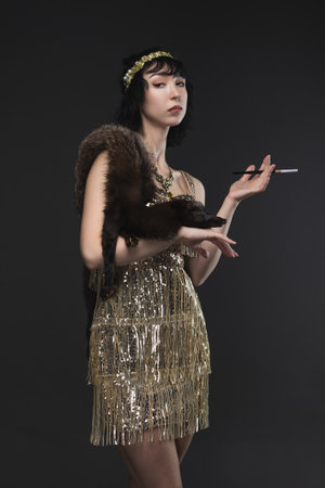 1920s femme fatale in gold Art Deco dress with beaded headband, brunette bob.