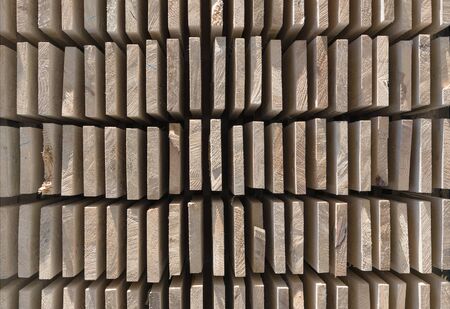 Piles of wooden boards in the sawmill, planking. Warehouse for sawing boards on a sawmill outdoors....