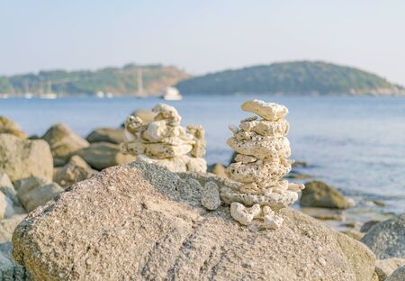 Pyramid of beach pebbles and coral on granite stones. Thailand. Phuketの写真素材