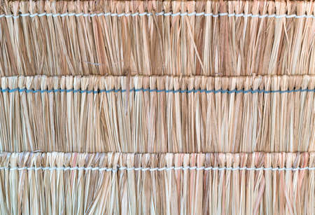 The texture of straws or thatched wicker roof in Asia. Thatch roof background, hay or dry grass...