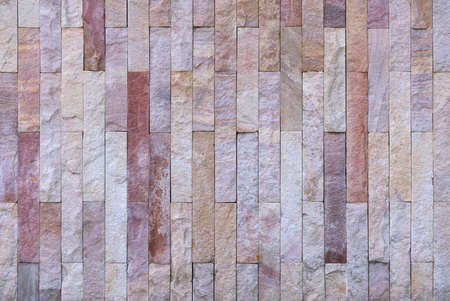 Stone cladding wall made of striped stacked slabs of natural brown rocks, panels for exterior