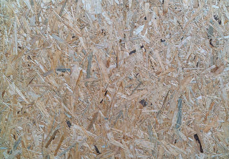 OSB boards are made of brown wood chips sanded into a wooden background. Top view of OSB wood veneer...