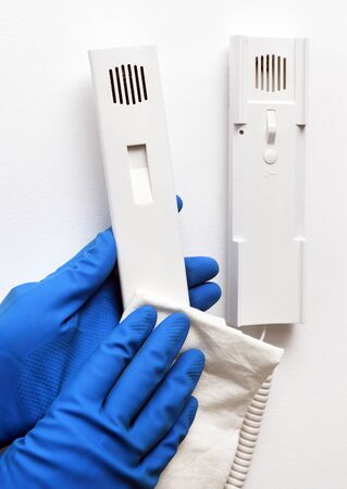 Disinfection in public places, the fight against the virus, coronavirus. The working hand wipes the...