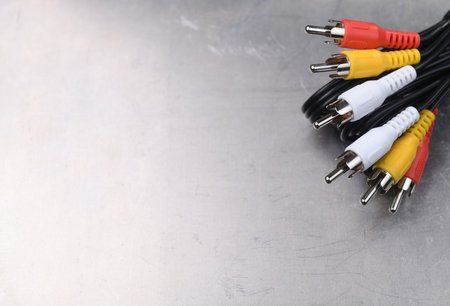 AV TV RCA composite audio-video cables on a gray metal background.Place for text.