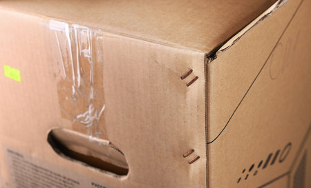 Metal staples on the corner of a cardboard box.Box staplers ensure fast and secure lid closing.A...