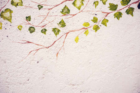 Abstract illustration on a plastered wall of a tree branch with leaves.の写真素材