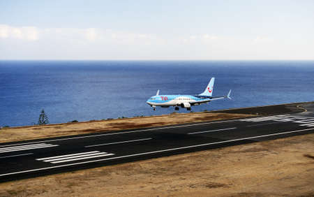 TUI Boeing 737. The Commercial jet aeroplane started the landing gear system for landing .. Airport Funchal, Madeira, Portugal. Atlantic Ocean. August 12, 2018.のeditorial素材
