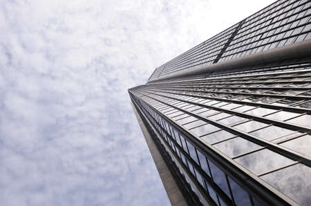 Bottom view of a tall glass building. Business center.の写真素材