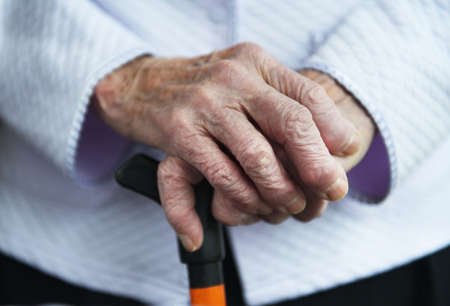 Hands of a mature wife or guardian holding the hands of her elderly woman or patient, as an expression of care and support. Close up photo of a dedicated caregiver holding an elderly woman's hands.の写真素材