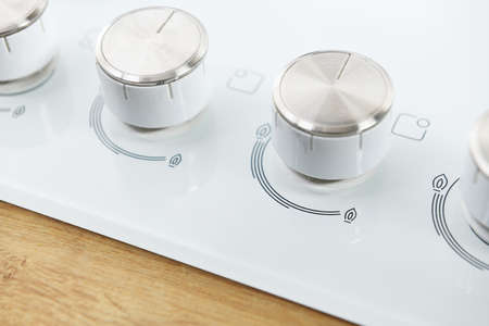 Close-up of a white power button on a white electric stoveの写真素材