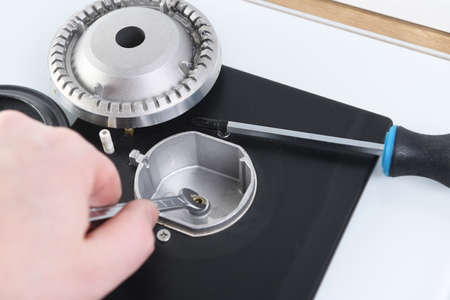 Close-up Of Person's Hand Repairing Electric Grill With Screwdriverの写真素材