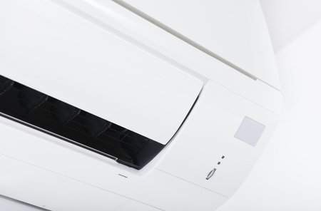 Air conditioner system on white wall room. Air conditioning.A white air conditioner is installed on a white wall in the apartment.の写真素材