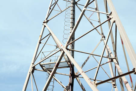 High-voltage tower against blue sky, closeup. Power supply
