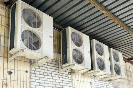 Air conditioner outdoor unit on the wall of a building, stock photo