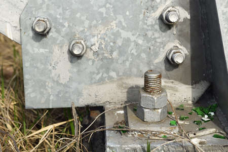 Close up of a nut and bolt on an old concrete structure.