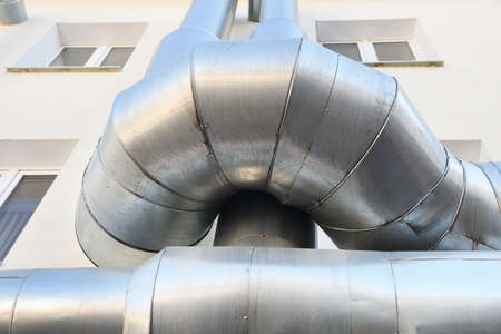 Large steel pipes of a heating system on the roof of a buildingの写真素材