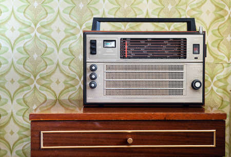 Retro radio on a wooden chest of drawers in a roomの写真素材