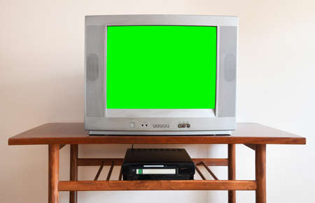 Old silver vintage green screen TV from 1980s, 1990s, 2000s, VCR on wallpaper background.の写真素材