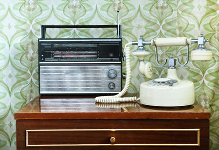 Retro telephone and receiver on a table in a roomの写真素材