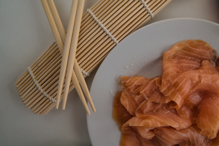Fine salmon fillet prepared for sushi on a white plateの写真素材