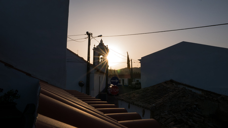 A sunset behing a church in a small portugues townの写真素材