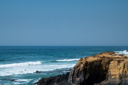 The coastline in portugal showing the ocean, cliffs, beach, and wavesの写真素材
