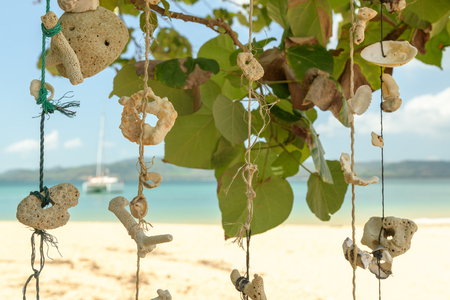 Hand-made articles from the hanging shells against the background of the seaの写真素材