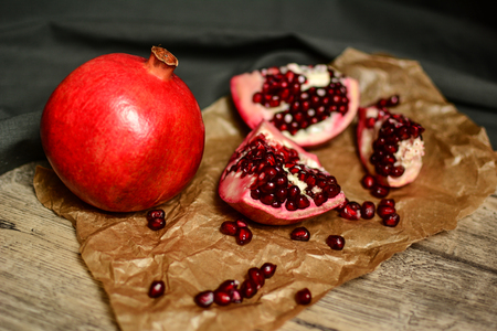 Ripe red cut pomegranate on the brownの写真素材