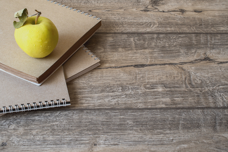 School notebook and green apple on wooden backgroundの写真素材